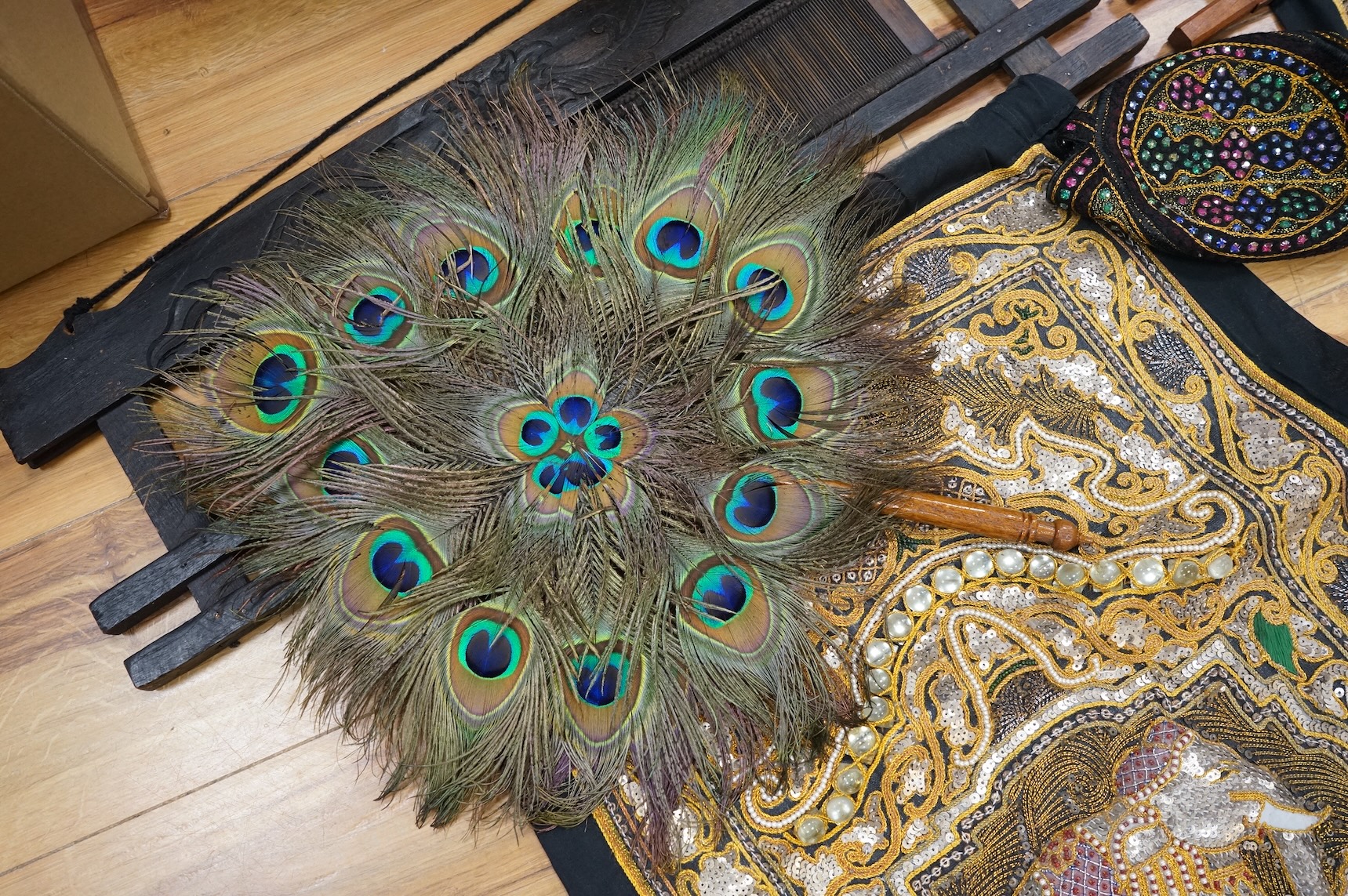 A quantity of mostly 20th century Middle Eastern and Indian woven and printed textiles and a peacock feather fan (2 boxes).